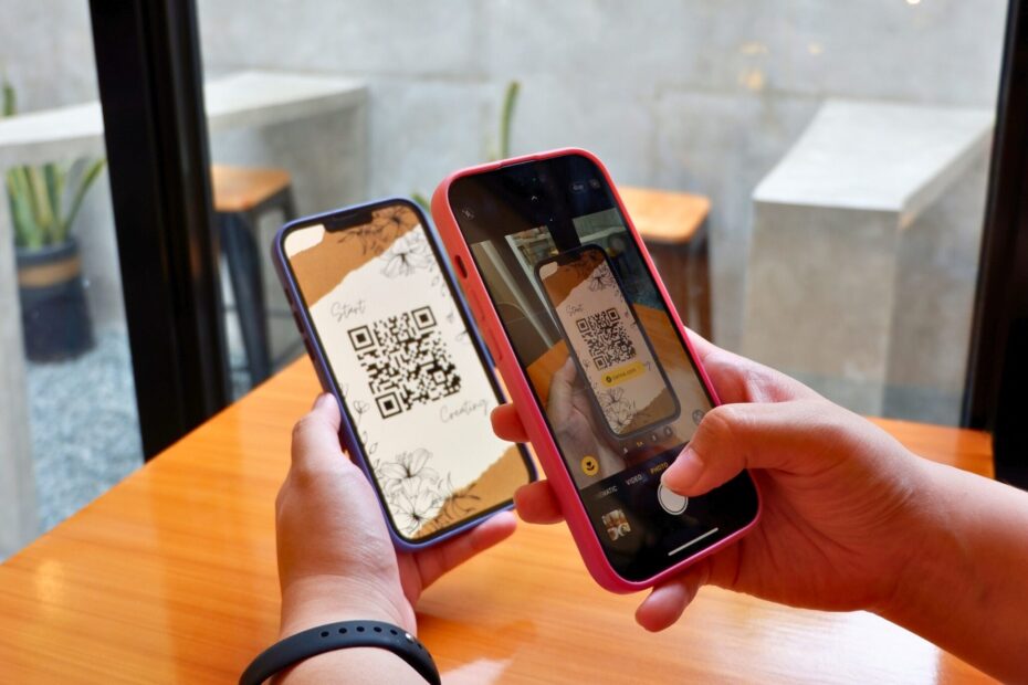 Two individuals displaying qr codes on their smartphones.