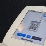 A white tablet featuring a QR code for contactless solutions.